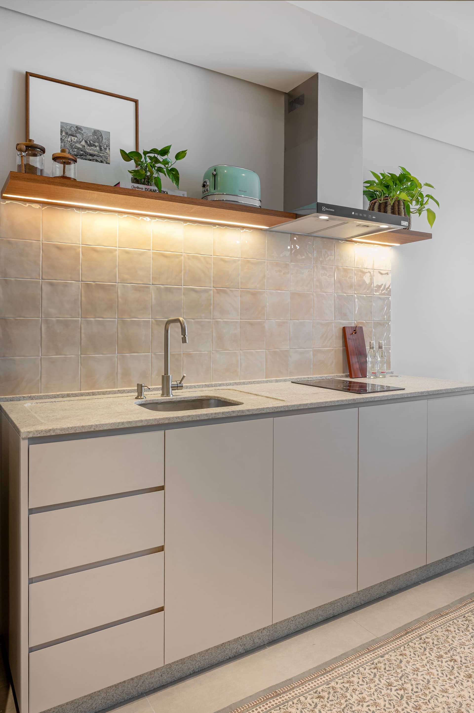 Bancada da cozinha com pia, cooktop de indução e coifa